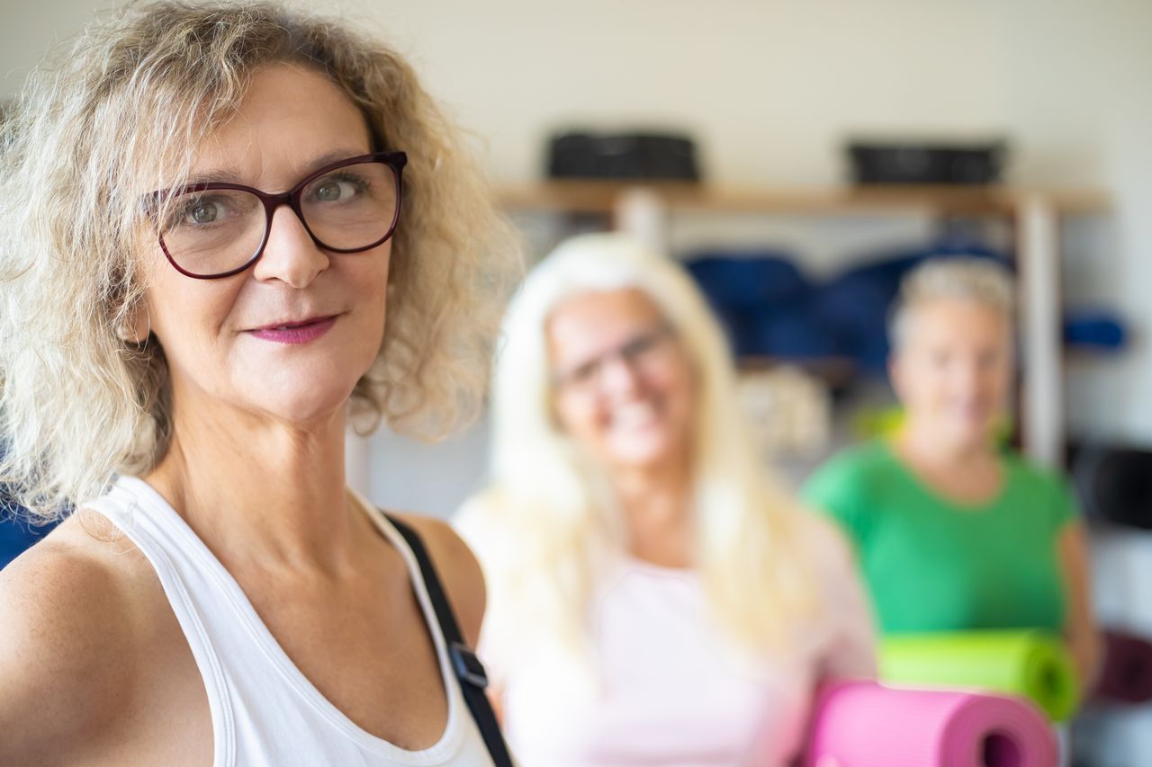 Group of senior women enjoying a fitness class with yoga mats. Positive and active lifestyle.